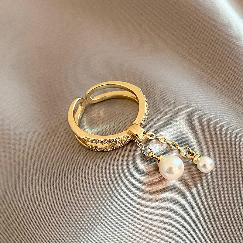 Bague pendentif anneaux croisés diamants perles