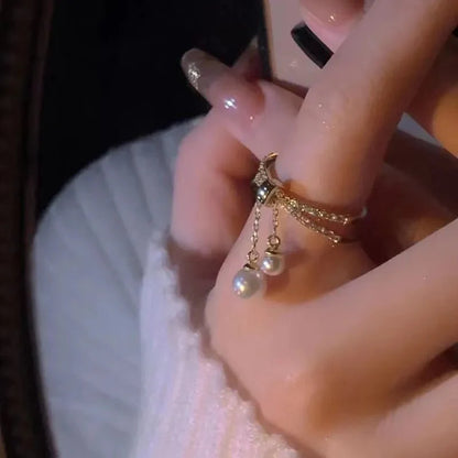 Bague pendentif anneaux croisés diamants perles