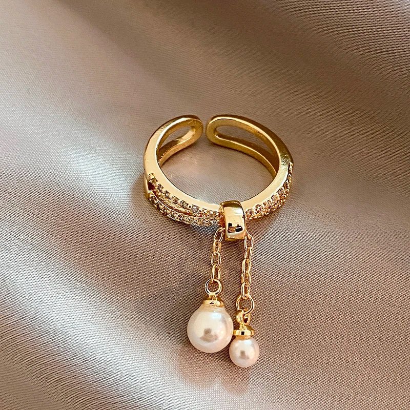 Bague pendentif anneaux croisés diamants perles
