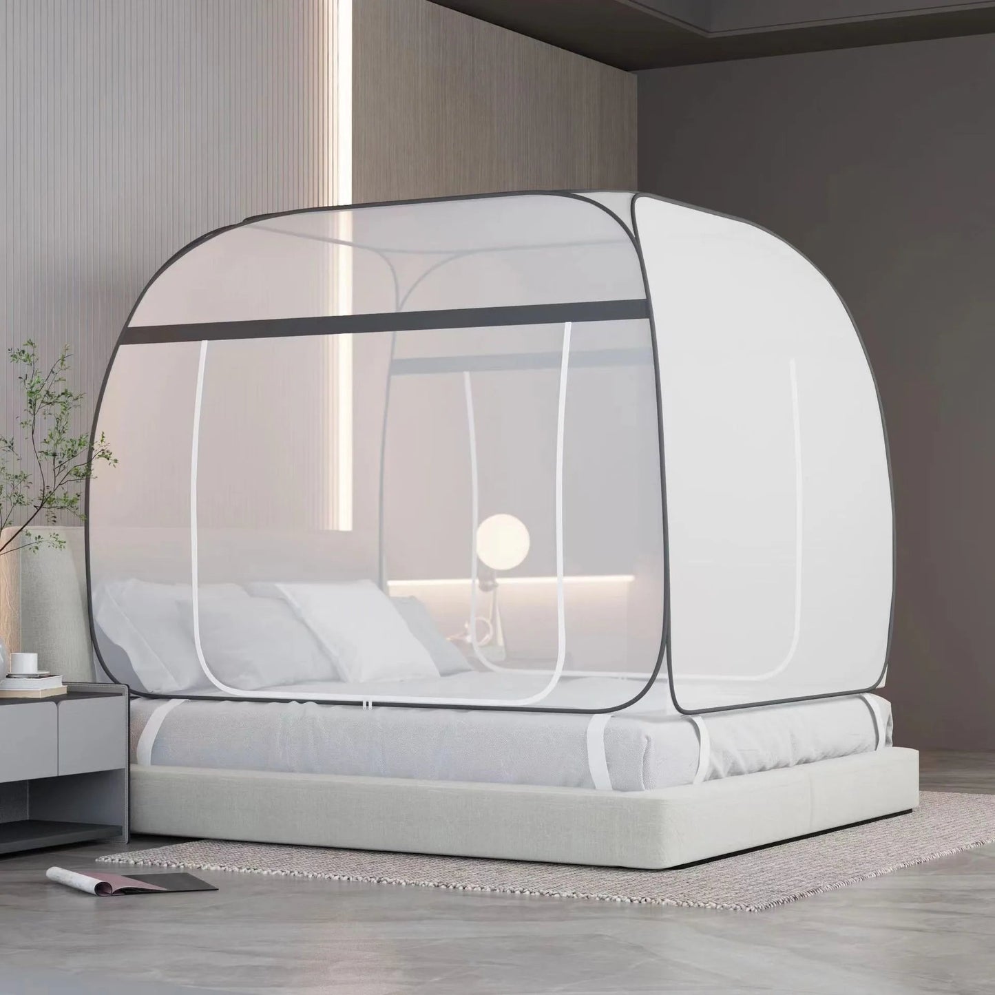 Moustiquaire Lit Carrée innovante facile à installer autour d'un lit avec des coussins et un drap blanc une table de nuit avec une plante verte et un meuble en fond avec une lampe